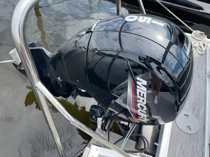 Slide: The Image of Mercury outboard motor on a 2022 Bennington 21 SX boat, docked on calm water. - 23