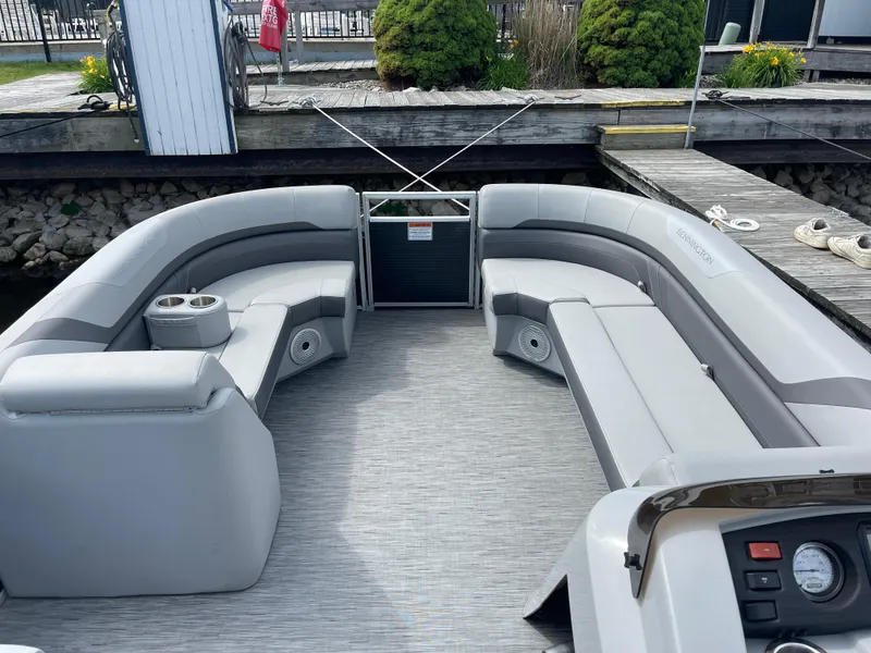 Slide: The Image of 2022 Bennington 21 SX pontoon boat with spacious seating and modern design at dock. - 6