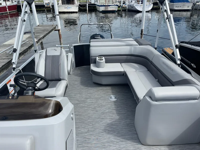 Slide: The Image of 2022 Bennington 21 SX pontoon boat with gray seating, docked at a marina. - 9