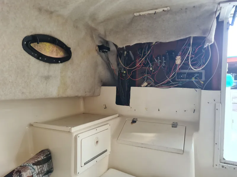 Slide: The Image of Interior of a 2000 Key West 2300 WA Bluewater boat showing wiring and storage compartments. - 13