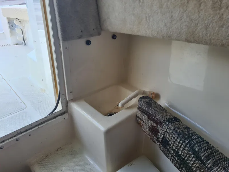 Slide: The Image of Interior view of a 2000 Key West 2300 WA Bluewater boat, featuring a small sink area. - 14