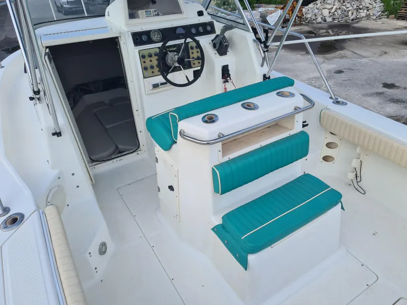 Slide: The Image of 2000 Key West 2300 WA Bluewater boat interior with teal seating and control panel. - 16