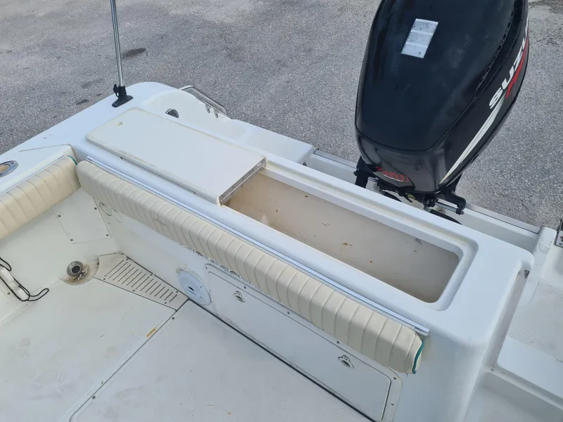 Slide: The Image of Key West 2300 WA Bluewater boat interior with open storage compartment and Suzuki outboard motor. - 17