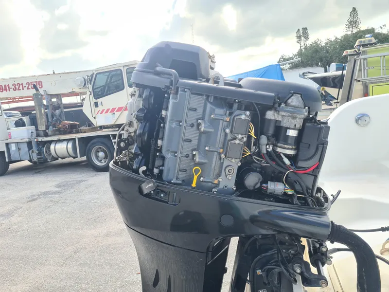 Slide: The Image of Outboard motor of a 2000 Key West 2300 WA Bluewater boat, with truck in background. - 23