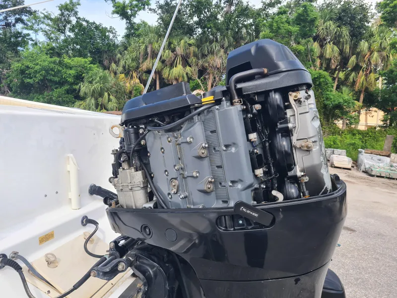 Slide: The Image of Outboard motor of a 2000 Key West 2300 WA Bluewater boat, surrounded by trees. - 24