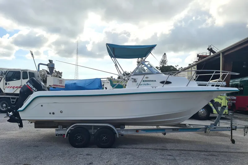 Slide: The Image of 2000 Key West 2300 WA Bluewater boat on trailer, parked outdoors. - 3