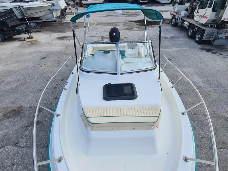 Slide: The Image of 2000 Key West 2300 WA Bluewater boat with canopy, docked in a marina. - 5