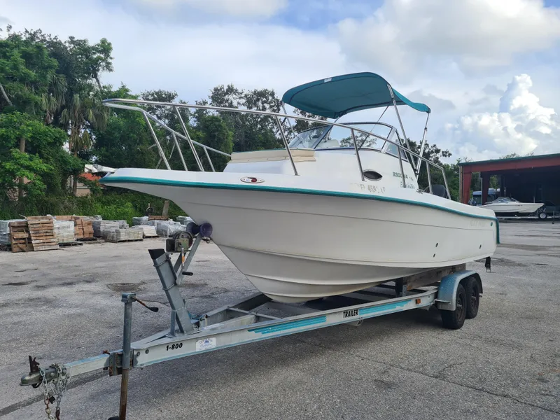 Slide: The Image of 2000 Key West 2300 WA Bluewater boat on trailer, parked outdoors. - 1