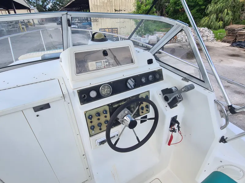Slide: The Image of 2000 Key West 2300 WA Bluewater boat cockpit with steering wheel and control panel. - 10