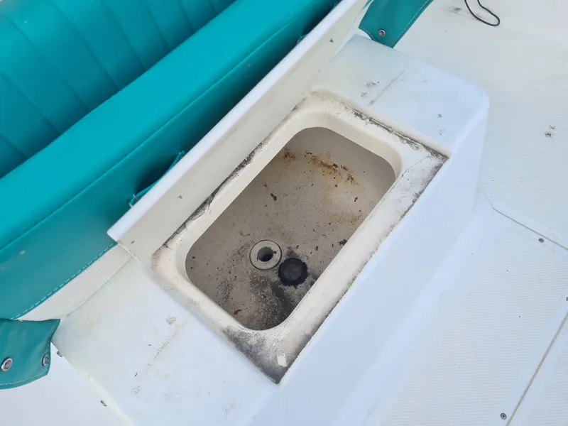Slide: The Image of Open storage compartment on 2000 Key West 2300 WA Bluewater boat with teal seating. - 18