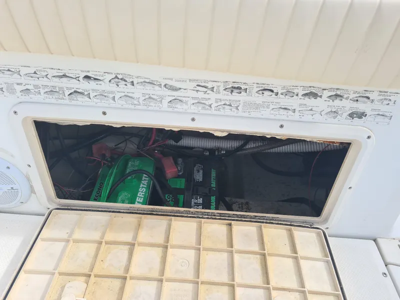 Slide: The Image of Key West 2300 WA Bluewater 2000 boat battery compartment with fish identification chart. - 20
