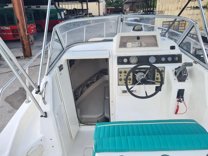 Slide: The Image of 2000 Key West 2300 WA Bluewater boat interior with steering wheel and control panel. - 9