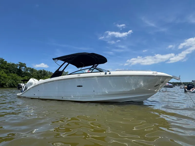 Slide: The Image of 2023 Sea Ray SDX 290 Outboard boat on calm water under clear blue sky. - 6