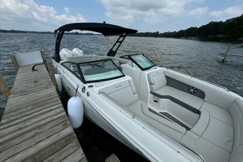 Slide: The Image of 2023 Sea Ray SDX 290 Outboard docked by a wooden pier on a lake. - 9
