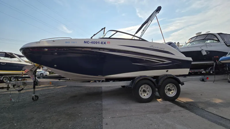 The Image of 2022 Hurricane SunDeck 191 OB boat on trailer, parked outdoors under clear sky. - 0
