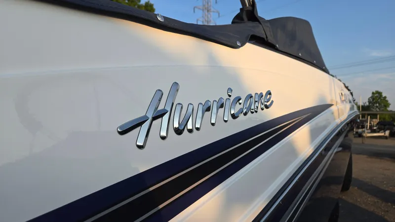 Slide: The Image of 2022 Hurricane SunDeck 191 OB boat with sleek design and chrome logo. - 11