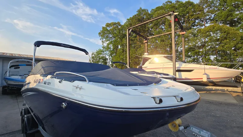 Slide: The Image of 2022 Hurricane SunDeck 191 OB boat in a marina, covered and ready for transport. - 9