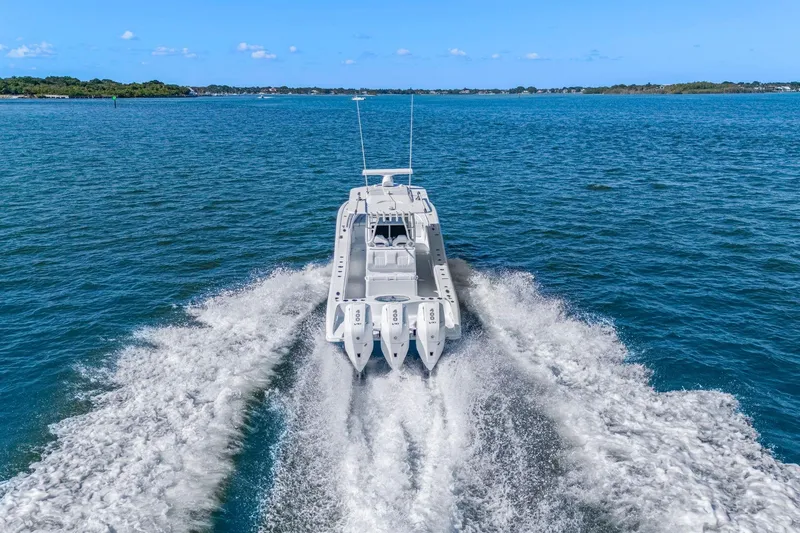 Slide: The Image of 2026 Yellowfin 36 Offshore boat cruising on open water, rear view. - 11