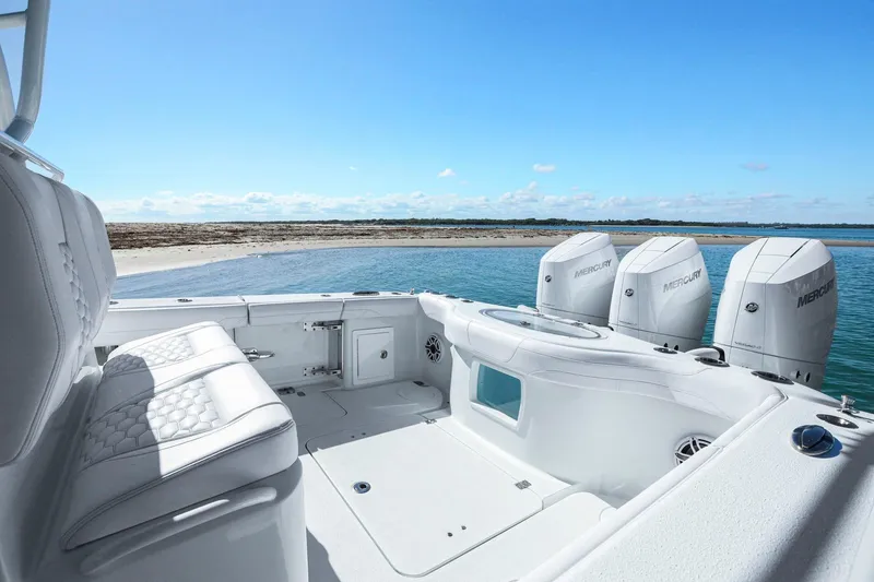 Slide: The Image of 2026 Yellowfin 36 Offshore boat with Mercury engines near a sandy shore. - 20