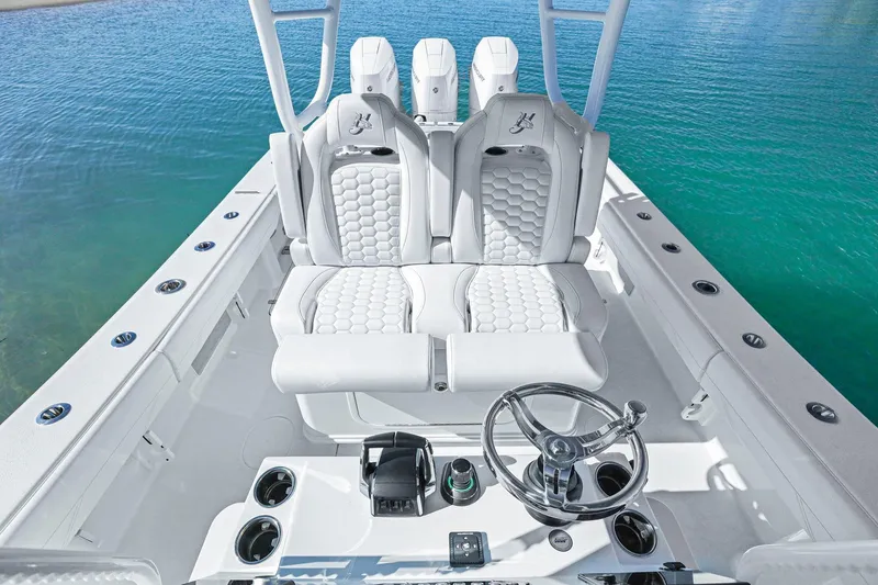 Slide: The Image of 2026 Yellowfin 36 Offshore boat interior with luxurious seating and steering wheel, on clear blue water. - 24