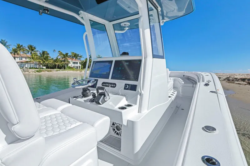 Slide: The Image of 2026 Yellowfin 36 Offshore boat with modern helm, docked by a sandy beach. - 28