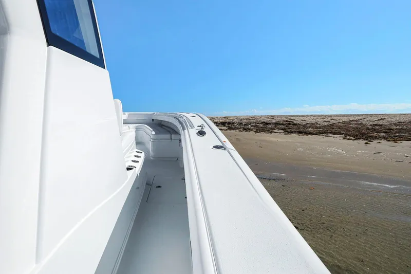 Slide: The Image of 2026 Yellowfin 36 Offshore boat on sandy beach under clear blue sky. - 29