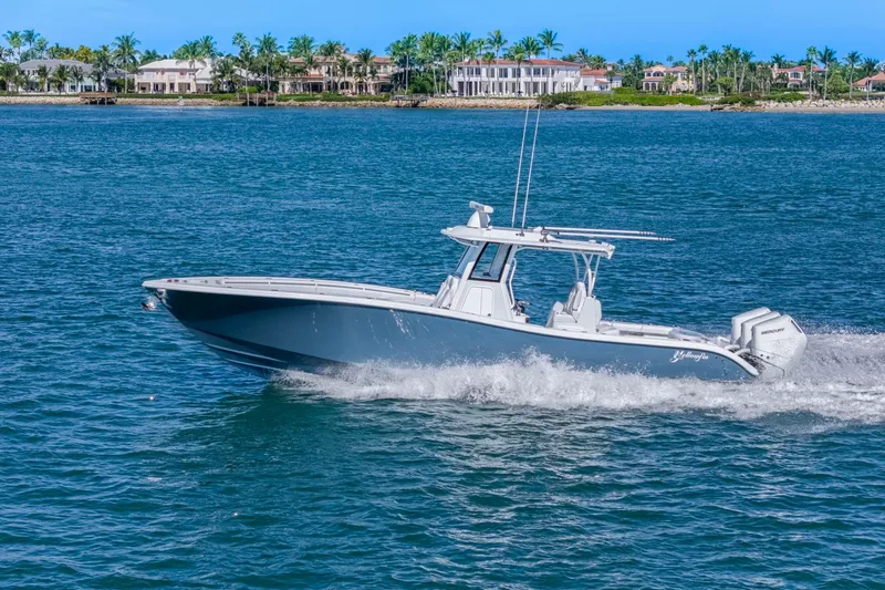 Slide: The Image of 2026 Yellowfin 36 Offshore boat cruising on blue ocean near luxury waterfront homes. - 3