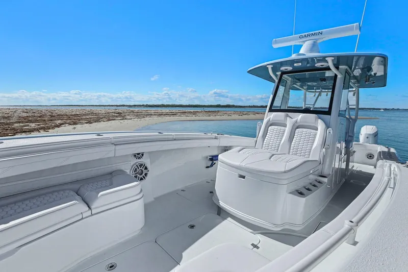 Slide: The Image of 2026 Yellowfin 36 Offshore boat interior with seating, near a sandy beach. - 32