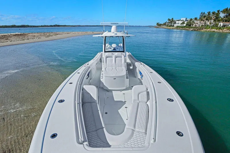Slide: The Image of 2026 Yellowfin 36 Offshore boat on clear blue water near a sandy shore. - 36