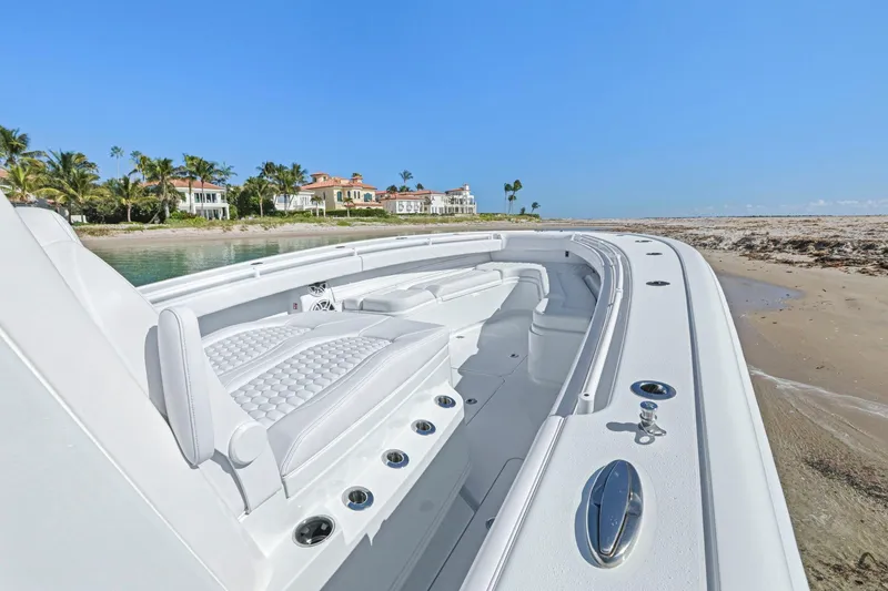 Slide: The Image of 2026 Yellowfin 36 Offshore boat on sandy beach with luxury homes in background. - 37