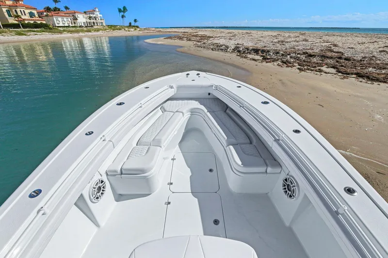 Slide: The Image of 2026 Yellowfin 36 Offshore boat with spacious seating, docked near a sandy beach. - 40