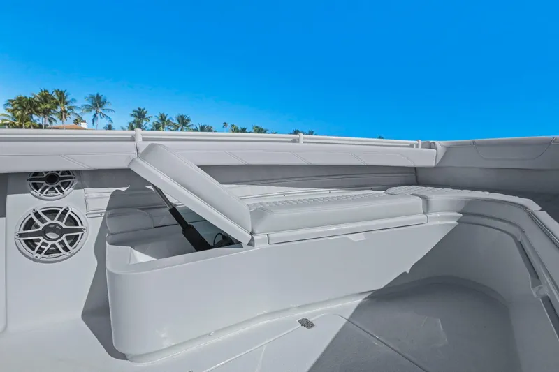 Slide: The Image of 2026 Yellowfin 36 Offshore boat interior with storage and speakers, under clear blue sky. - 42