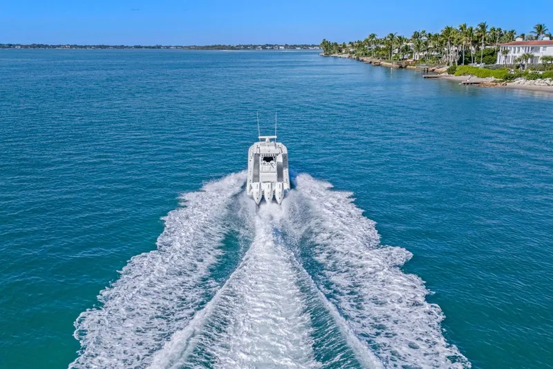 Slide: The Image of 2026 Yellowfin 36 Offshore boat cruising on clear blue water near a tropical coastline. - 5