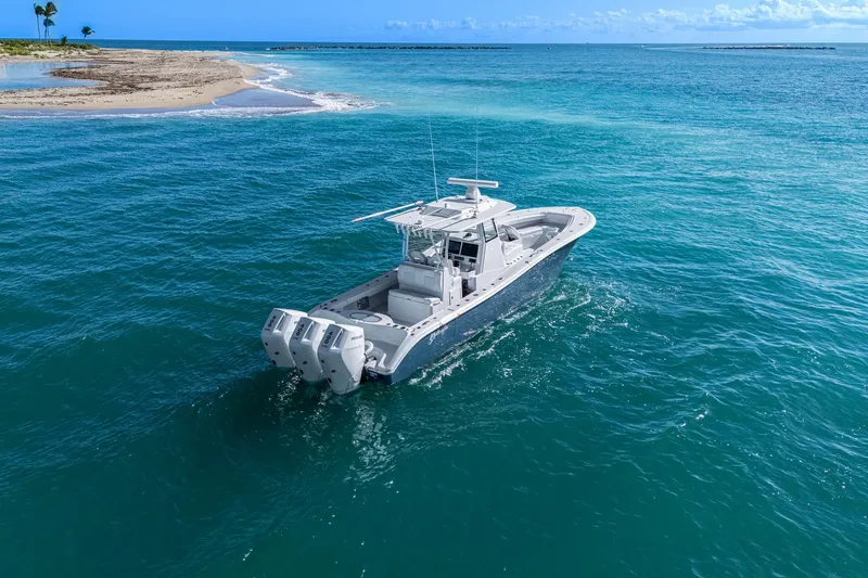 Slide: The Image of 2026 Yellowfin 36 Offshore boat cruising near a sandy island in clear blue waters. - 55