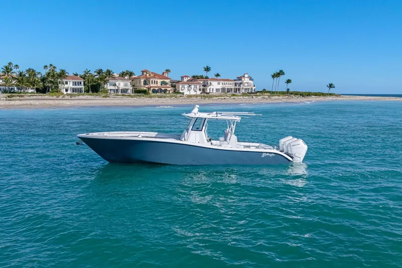 Slide: The Image of 2026 Yellowfin 36 Offshore boat on turquoise water near luxury beachfront homes. - 59