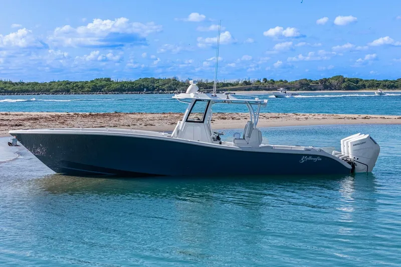 Slide: The Image of 2026 Yellowfin 36 Offshore boat anchored on a sandy beach with clear blue water. - 60