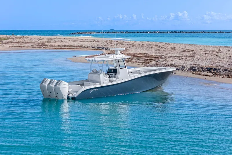 Slide: The Image of 2026 Yellowfin 36 Offshore boat anchored near sandy beach, clear blue water. - 62
