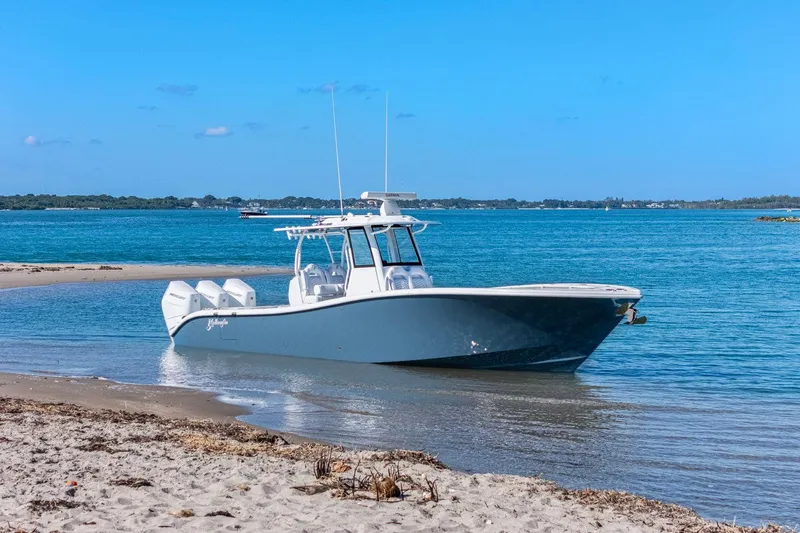 Slide: The Image of 2026 Yellowfin 36 Offshore boat on sandy shore with blue ocean backdrop. - 65