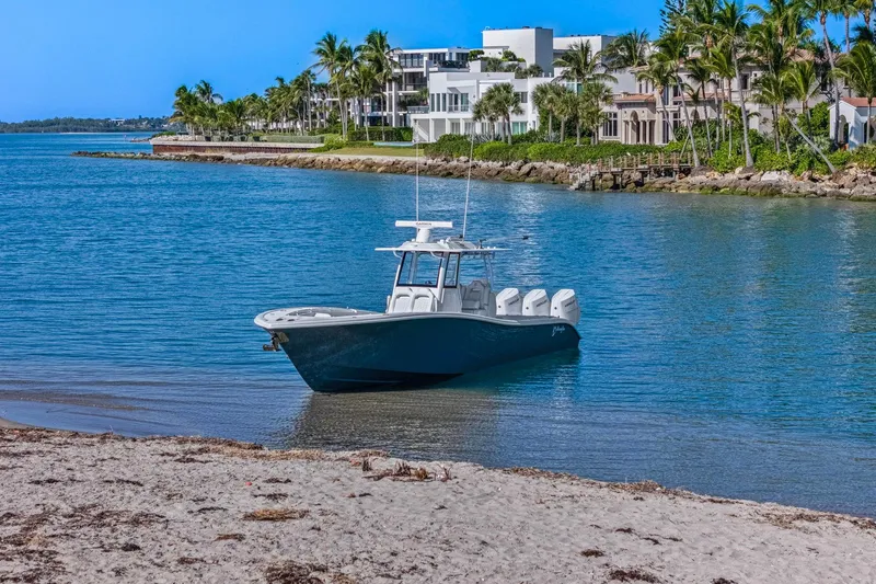 Slide: The Image of 2026 Yellowfin 36 Offshore boat near tropical shoreline with luxury homes. - 66