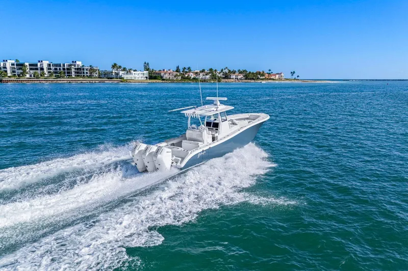 Slide: The Image of 2026 Yellowfin 36 Offshore boat cruising on clear blue water near coastal buildings. - 9
