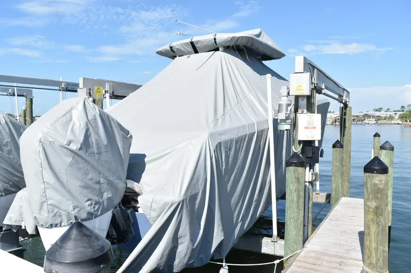 Slide: The Image of Covered 2025 Caymas 34 CT boat docked, with protective tarps, under clear blue sky. - 14