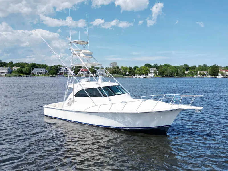 The Image of 2022 Henriques 42 Express Hardtop boat on calm water under blue sky. - 0
