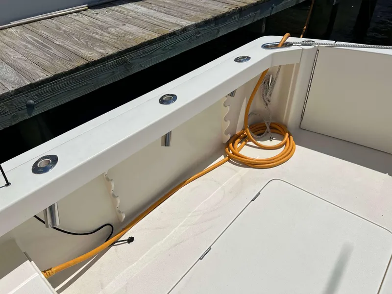 Slide: The Image of 2022 Henriques 42 Express Hardtop boat deck with coiled orange cable and dock view. - 21