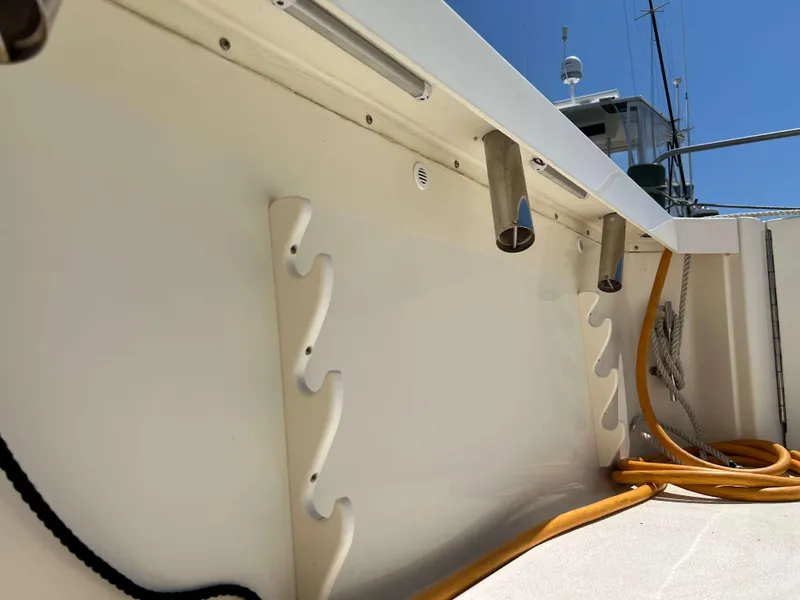 Slide: The Image of 2022 Henriques 42 Express Hardtop boat deck with rod holders and coiled cables. - 22