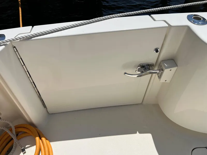 Slide: The Image of 2022 Henriques 42 Express Hardtop boat deck with latch and coiled rope. - 23