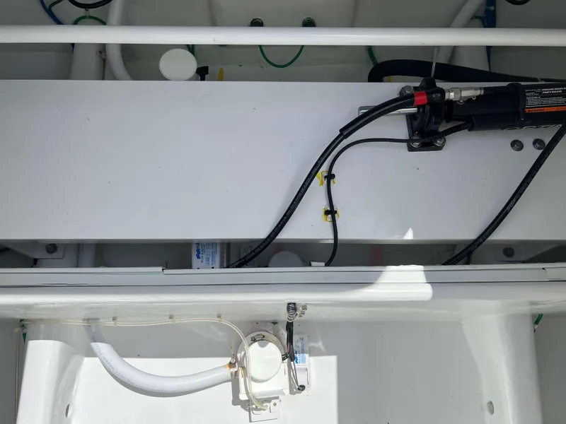 Slide: The Image of Engine compartment of a 2022 Henriques 42 Express Hardtop boat, showing hydraulic and electrical components. - 29