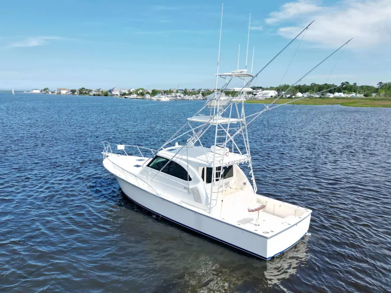 Slide: The Image of 2022 Henriques 42 Express Hardtop boat on calm water under clear blue sky. - 4