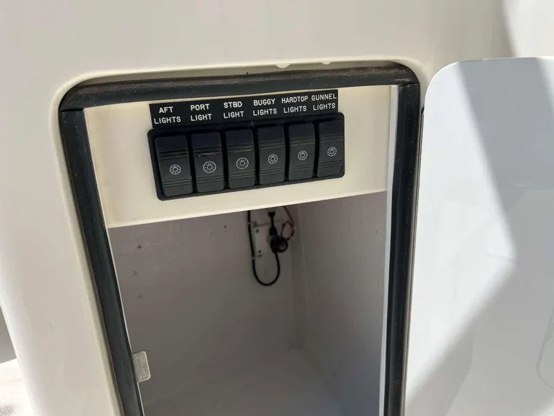 Slide: The Image of Control panel on a 2022 Henriques 42 Express Hardtop boat, featuring labeled light switches. - 40