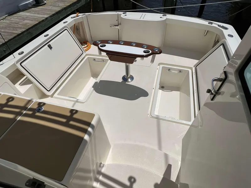 Slide: The Image of 2022 Henriques 42 Express Hardtop boat deck with storage compartments and fishing rod holders. - 42