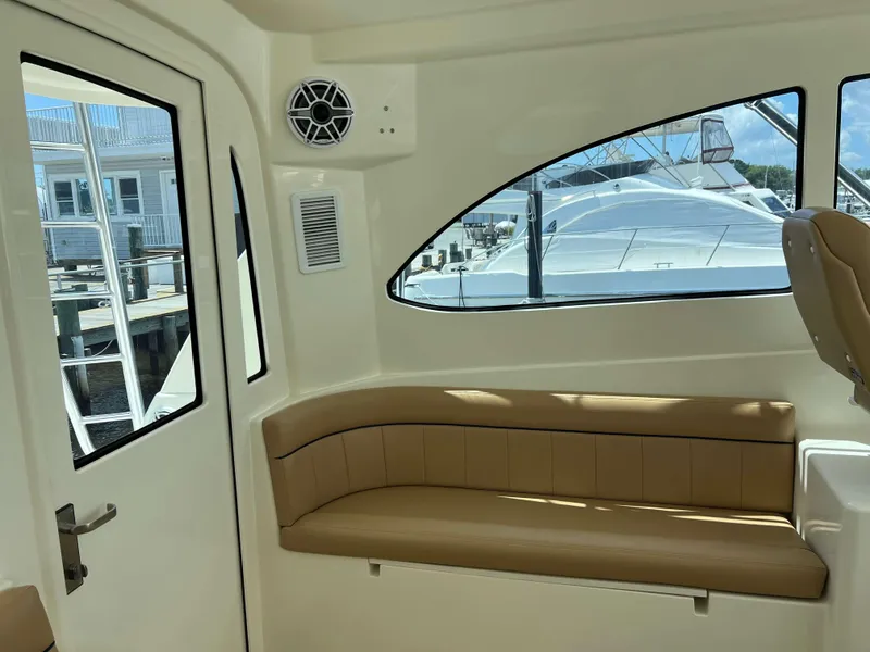 Slide: The Image of Interior of 2022 Henriques 42 Express Hardtop yacht with tan seating and window view. - 45